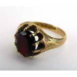 A late 19th century 15ct yellow gold ring set oval garnet in a raised ten claw setting within