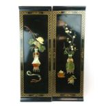 Two Japanese black lacquerwork panels each set semi-precious stones in the form of vases of flowers,