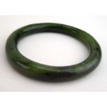 A mottled green jade bangle, internal d. 5.