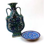An Iznik two handled stoneware vase of flat shield shaped form decorated with stylised flowers on a