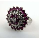 An 18ct white gold cluster ring set two bands of diamonds and rubies, ring size M, 6.