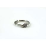 A platinum ring set single brilliant cut diamond in a rubover crossover setting, ring size N, 5.