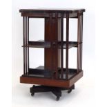An Edwardian mahogany, crossbanded and marquetry revolving bookcase with a serpentine top, h.