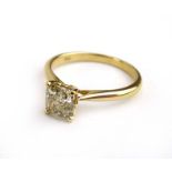 An 18ct yellow gold ring set cushion cut yellow diamond in a raised four claw setting,