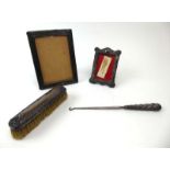 Two silver mounted photograph frames, a silver handled button hook and a silver backed hairbrush,