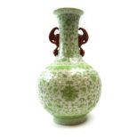 A Chinese two handled vase of elongated globular form decorated in pale green enamel with