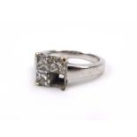 An 18ct white gold ring set three princess cut diamonds in a square shaped setting, ring size K, 4.