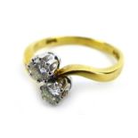 An 18ct yellow gold crossover ring set two brilliant cut diamonds,