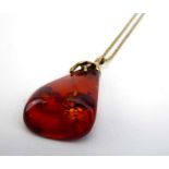 A 9ct yellow gold ropetwist necklace suspending a 9ct yellow gold pendant set amber, pendant drop 4.