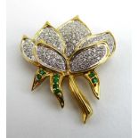 An 18ct yellow gold brooch in the form of a lotus flower and set diamonds and emeralds, w. 3.
