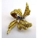 An 18ct yellow gold brooch in the form of a bow and set sapphires and diamonds, w. 3.9 cm, 16.