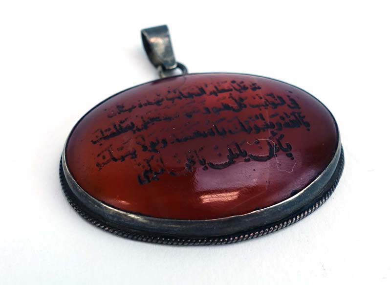 A metalware mounted cornelian pendant of oval form carved with Islamic text, w. - Image 2 of 2