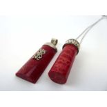 A silver boxlink necklace suspending a red sponge coral pendant of cylindrical form,