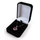 A 9ct white gold fine boxlink necklace suspending a 9ct white gold pendant of bowed diamond shaped