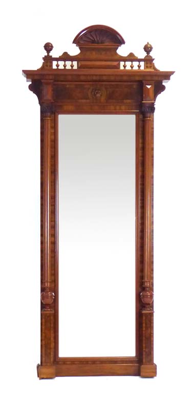 A late 19th/early 20th century walnut and ebony strung pier mirror with a figural carving and shell