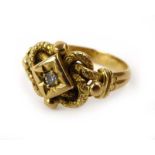 An early 20th century 18ct yellow gold ring of entwined form set centrally with a small diamond,