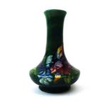 A Moorcroft miniature vase decorated with iris on a shaded green ground,