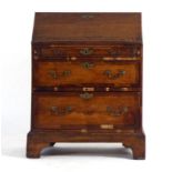 A Georgian oak bureau, the fall front over three long graduated drawers, w.