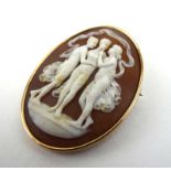 A yellow metal mounted oval brooch inset carved cameo depicting the three graces, l. 4.