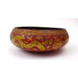 A Chinese paper mache bowl of circular form gilt decorated with dragons and bats on a red ground, d.