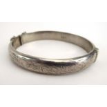 A silver and florally engraved hinged bracelet, hallmarked for Birmingham 1961, internal w. 6.