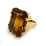 An 18ct yellow gold dress ring set emerald cut citrine in a raised eight claw setting,