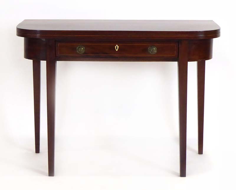 An early 19th century mahogany and strung side/tea table with a folding surface over a single