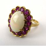 An 18ct yellow gold cluster ring set oval opal in a surround of fourteen rubies, ring size N, 6.