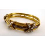 A late 19th/early 20th century yellow metal bracelet decorated with three x-shaped motifs set small