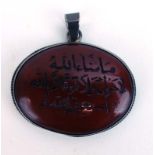 A metalware mounted cornelian pendant of oval form carved with Islamic text, w. 4.