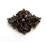A 19th century yellow metal mourning brooch of rococo design set pink teardrop stones within a