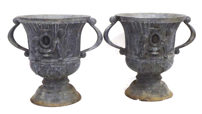 A pair of lead urns relief decorated in the Neo-Classical manner, h.