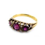 A late 19th century 18ct yellow gold ring set three graduated rubies interspersed with four rose