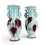 A pair of modern Chinese two handled vases of slender ovoid form decorated in a sang de boeuf glaze