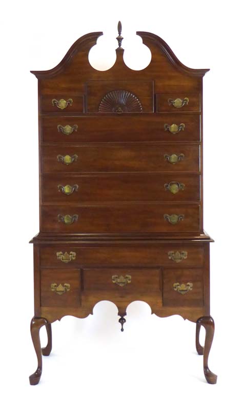 An American reproduction chest-on-stand, the eleven drawers over a shaped apron on cabriole legs,