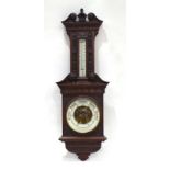 An early 20th century oak cased aneroid barometer in a carved case of architectural form, h.
