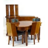 An Art Deco walnut dining suite in the manner of Epstein including a drawer-leaf dining table with
