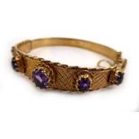 A 9ct yellow gold bracelet set five graduated amethysts within a diamond shaped engraved band and