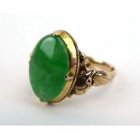 A 14ct yellow gold ring set oval jade within a foliate setting, ring size N, 3.