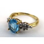 A 9ct yellow gold dress ring set pale blue oval stone and small diamonds, ring size N 1/2, 2.