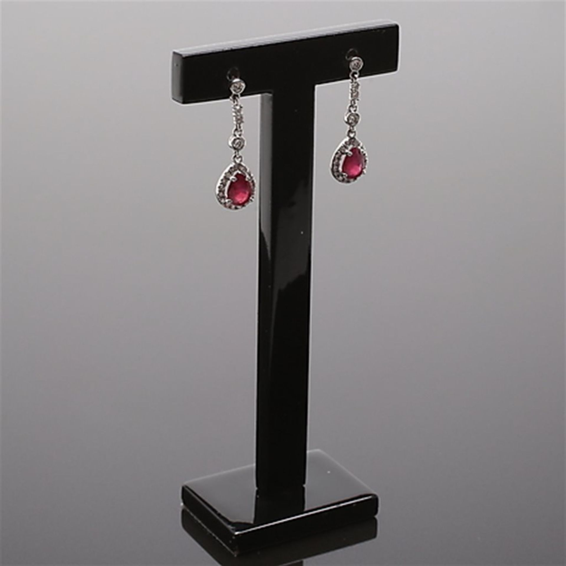 Earrings in white gold with diamonds and red stones.