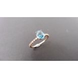 0.80ct / 0.12ct blue zircon and diamond dress ring. Oval cut ( treated ) zircon with small