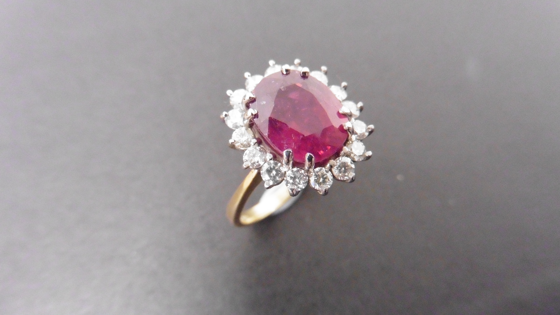 2.40ct ruby and diamond cluster ring set with a oval cut(glass filled) ruby which is surrounded by