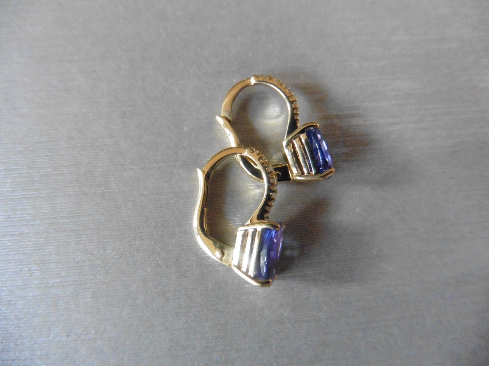 1.60ct Tanzanite and diamond hoop style earrings. Each is set with a 7x 5mm oval cut Tanzanite ( - Image 2 of 3