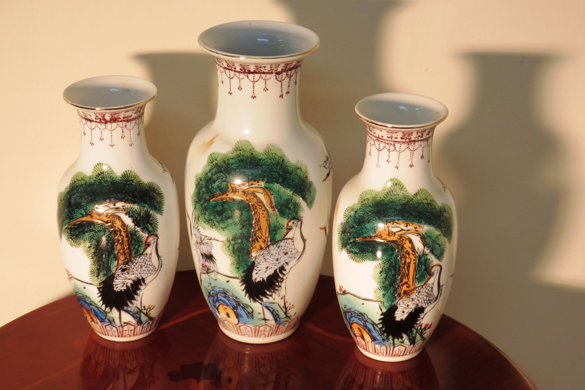 THREE ORIENTAL DECORATIVE PORCELAIN VASES DEPICTING CRANE BIRDS - CHINESE MARKINGS TO THE BASE