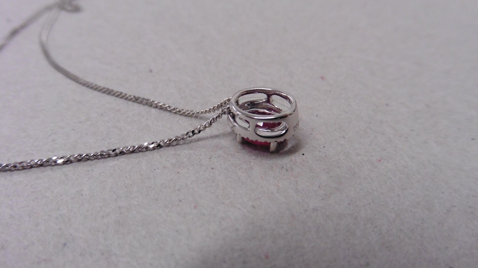 0.80ct ruby and diamond pendant. 7 x5mmoval cut ( glass filled ) ruby with a halo setting of small - Bild 2 aus 2