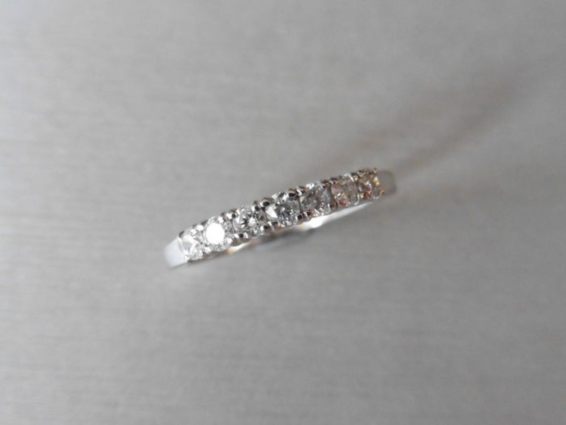 0.42ct diamond band ring set in 9ct white gold. 7 Small brilliant cut diamonds, I colour and i1