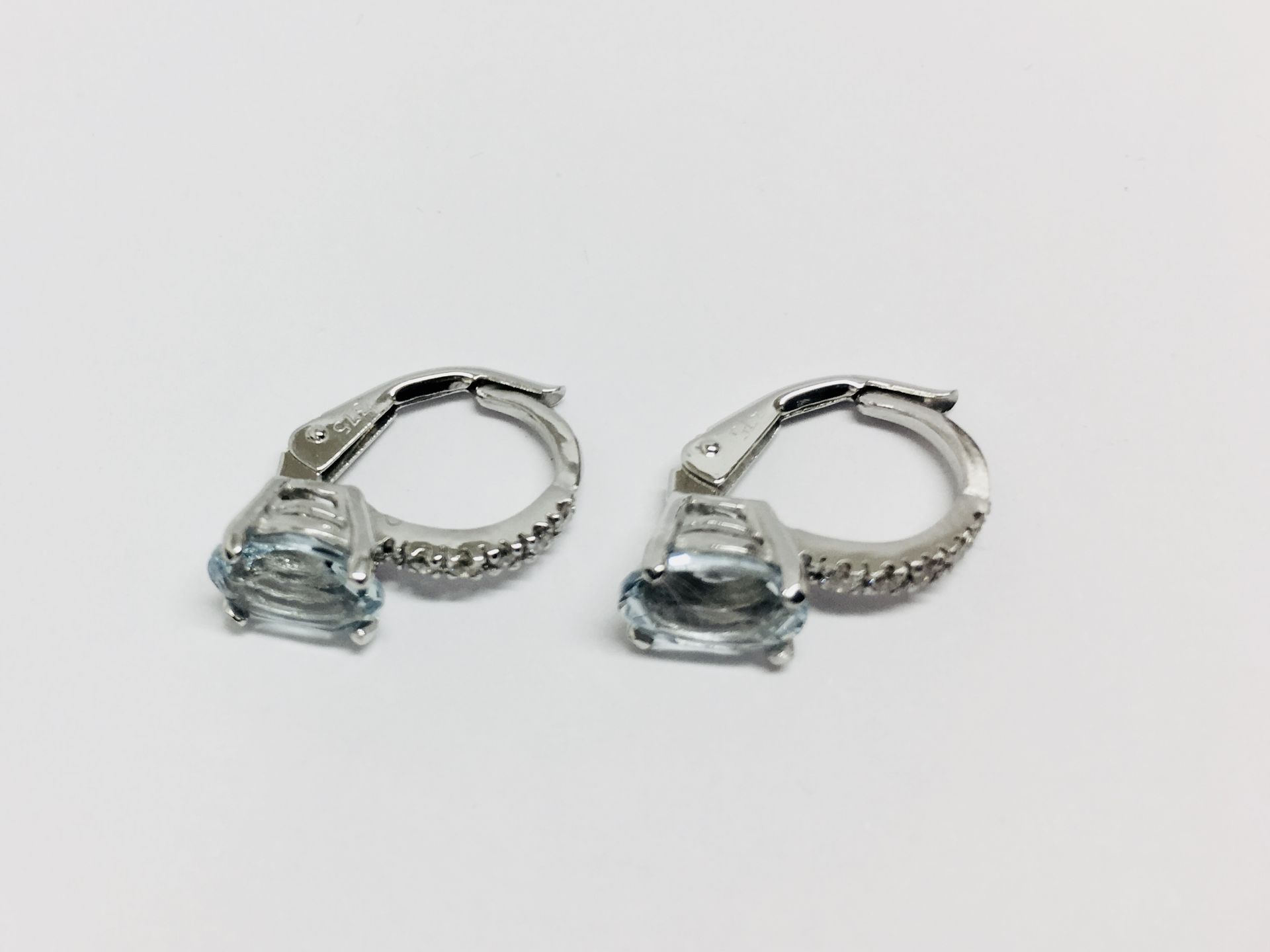 1.60ct Aqua marine and diamond hoop style earrings. Each is set with a 7x 5mm oval cut aqua ( - Image 2 of 3