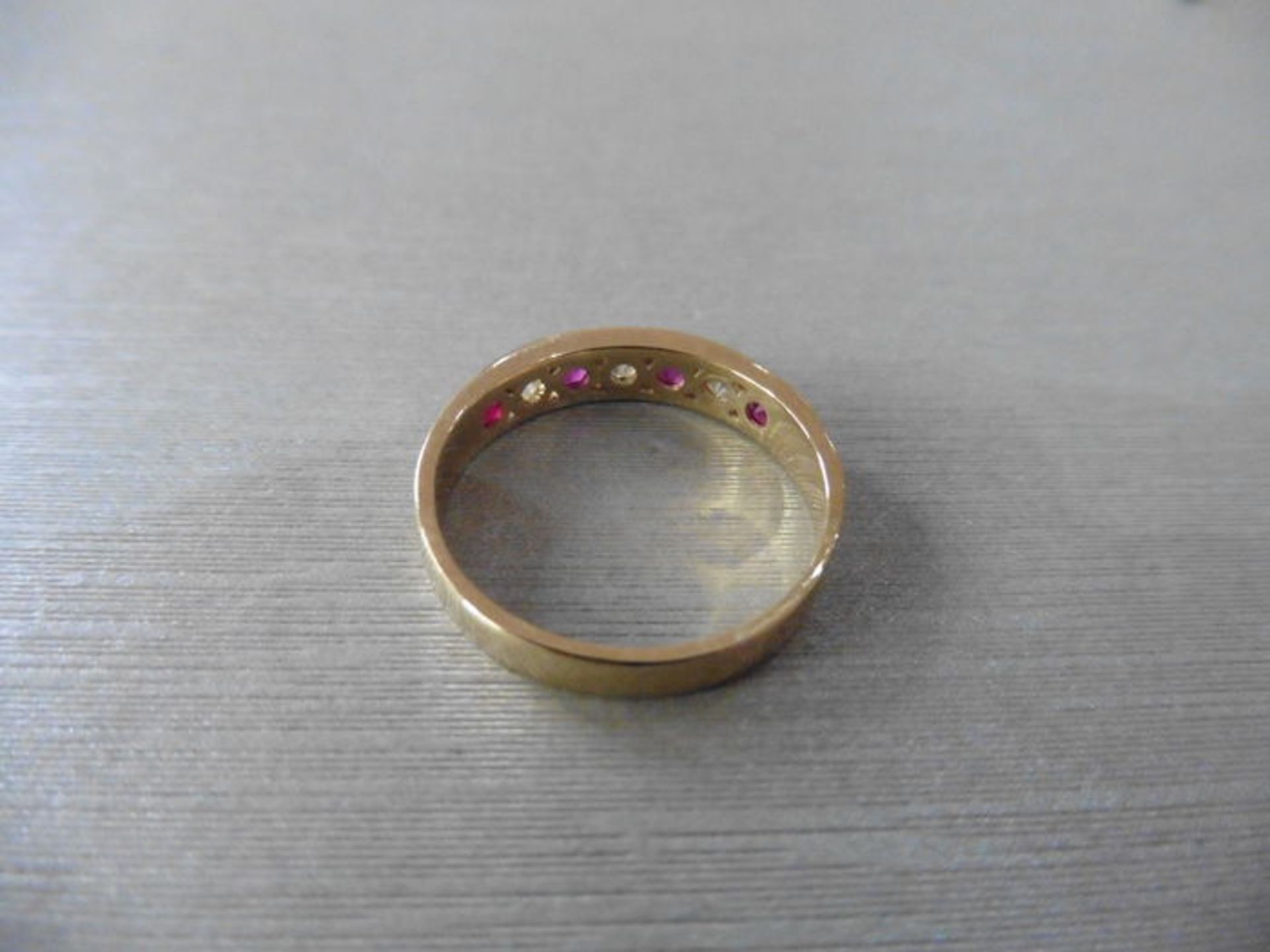 Ruby and diamond eternity band ring set in 9ct yellow gold. 4 small round cut rubies ( treated ) 0. - Image 3 of 3