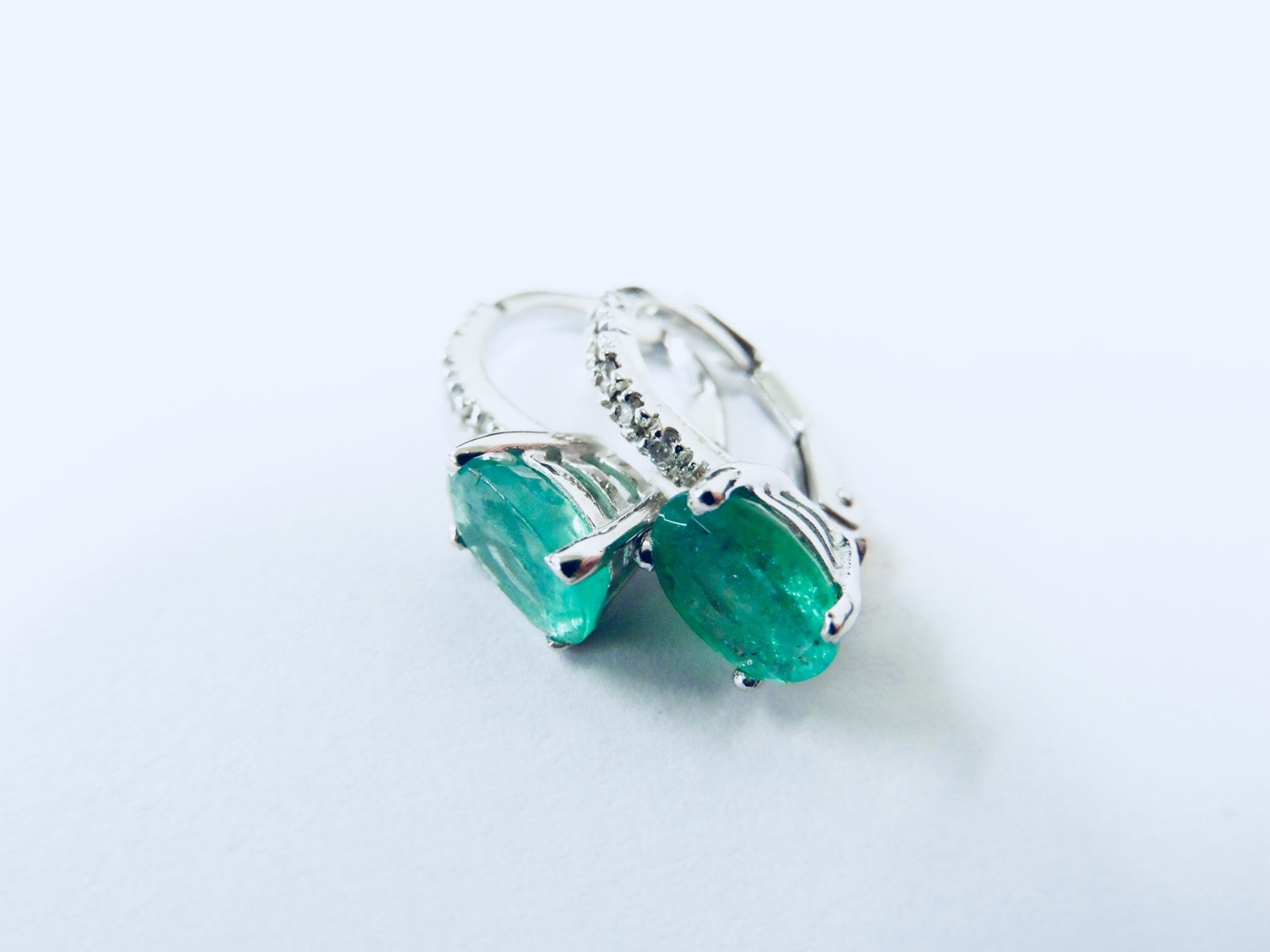 1.60ct emerald and diamond hoop style earrings. Each is set with a 7x 5mm oval cut emerald ( treated - Image 2 of 4